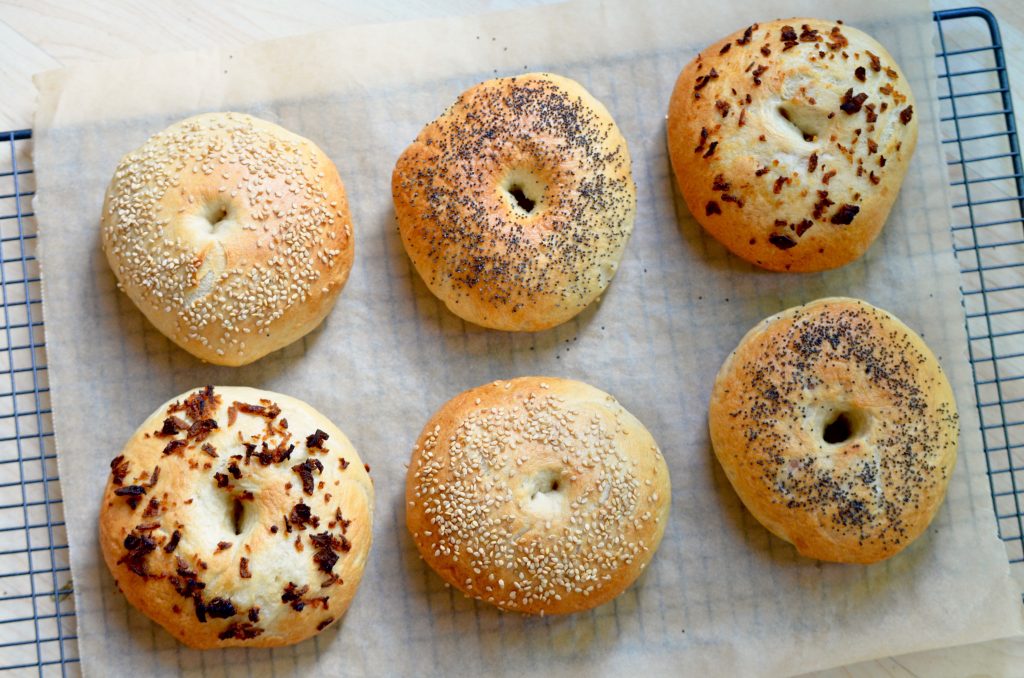 sesame, poppyseed and onion bagels on cooling rack