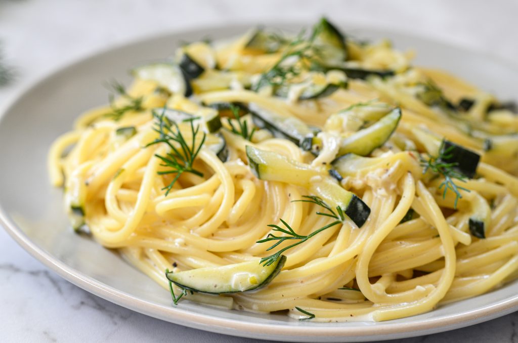 close image of creamy courgette pasta served with fresh chopped dill